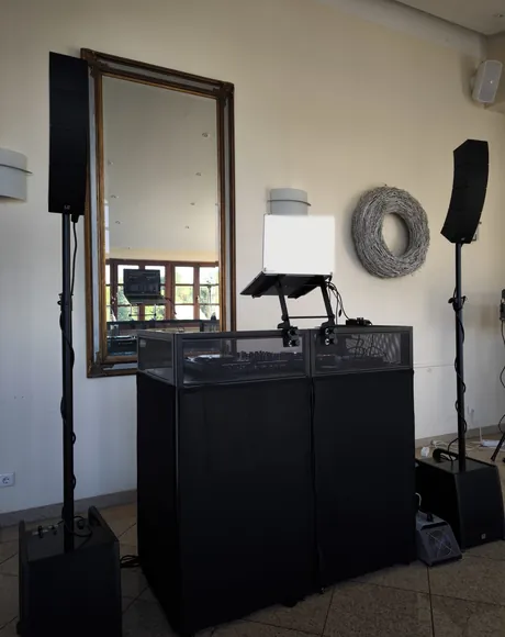 Aufgebautes DJ-Pult mit Boxen in einer Eventlocation